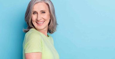 Profile side photo of cheerful old woman good mood smile retired lady isolated on pastel blue color background.